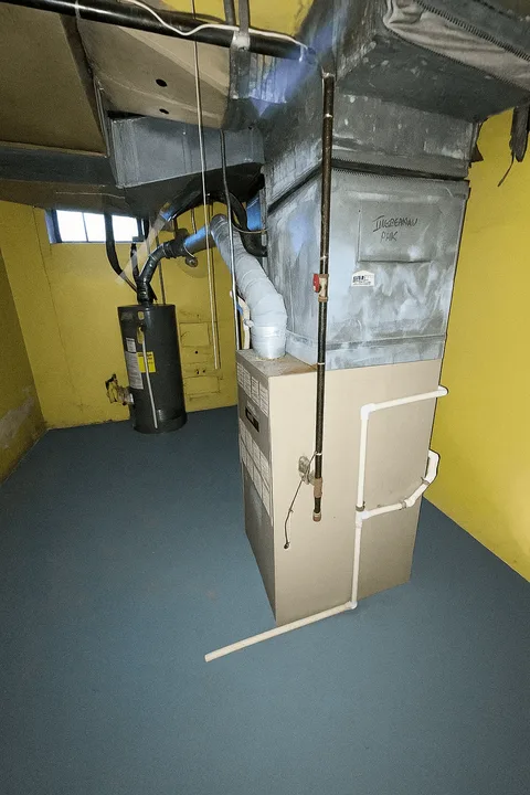 Example: a furnace photographed from the side showing the vent pipes and gas line